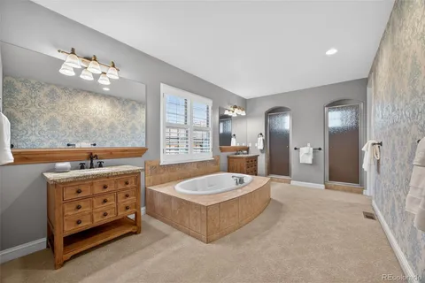 a spacious bathroom with a granite countertop tub sink and mirror