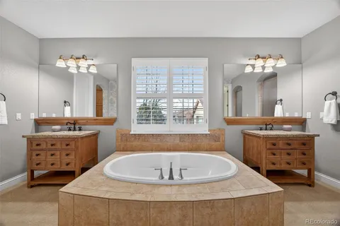 a spacious bathroom with a tub sink and mirror