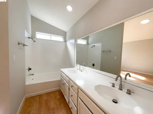 a bathroom with a tub sink and mirror