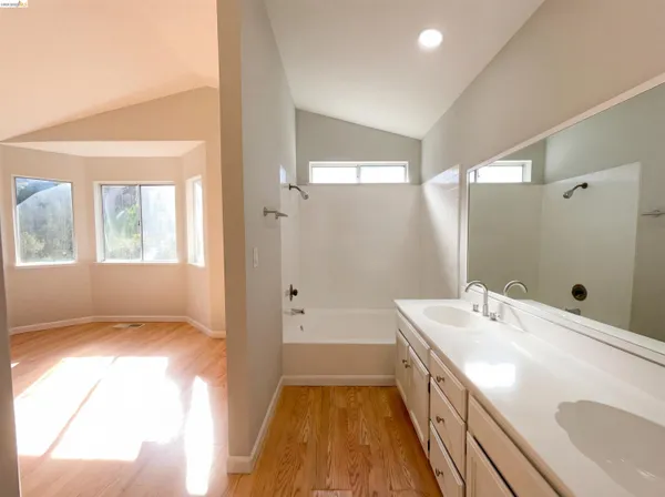 a bathroom with a sink a large mirror and a bathtub