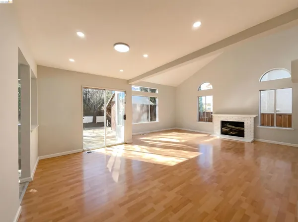 a view of an empty room with a fireplace and a window