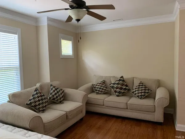 a living room with furniture and a wooden floor
