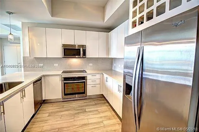a kitchen with granite countertop a refrigerator and a sink