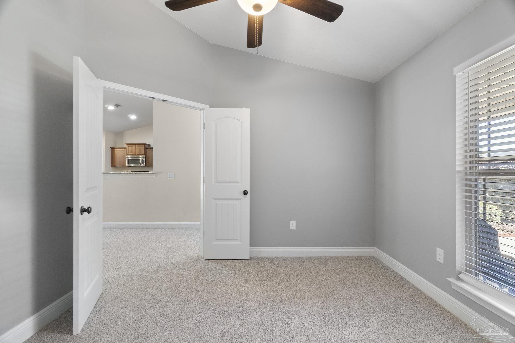5607 Cane Syrup Circle Pace, FL 32571 - Photo 11 of 54 an empty room with windows and chandelier fan