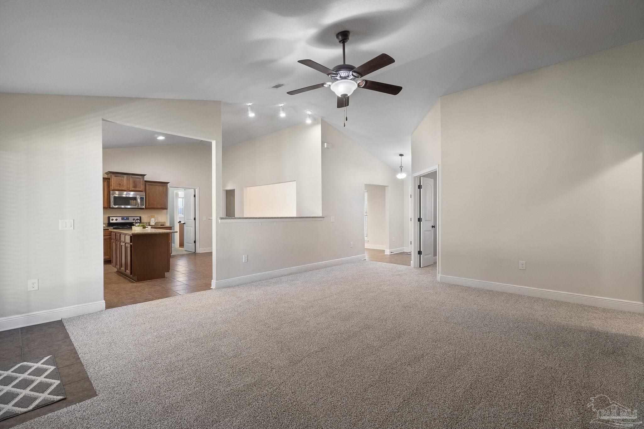 5607 Cane Syrup Circle Pace, FL 32571 - Photo 15 of 54 a view of a livingroom with a ceiling fan and kitchen space