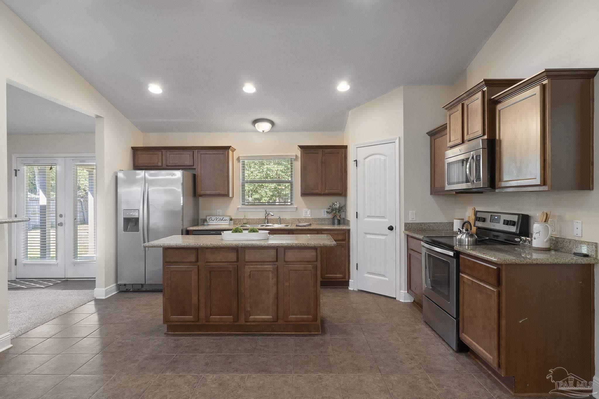 5607 Cane Syrup Circle Pace, FL 32571 - Photo 19 of 54 a kitchen with stainless steel appliances granite countertop a refrigerator stove and sink