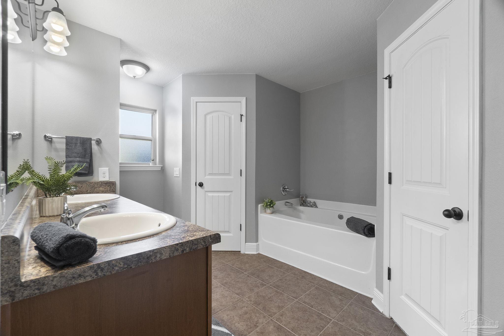 5607 Cane Syrup Circle Pace, FL 32571 - Photo 27 of 54 a bathroom with a tub sink and mirror