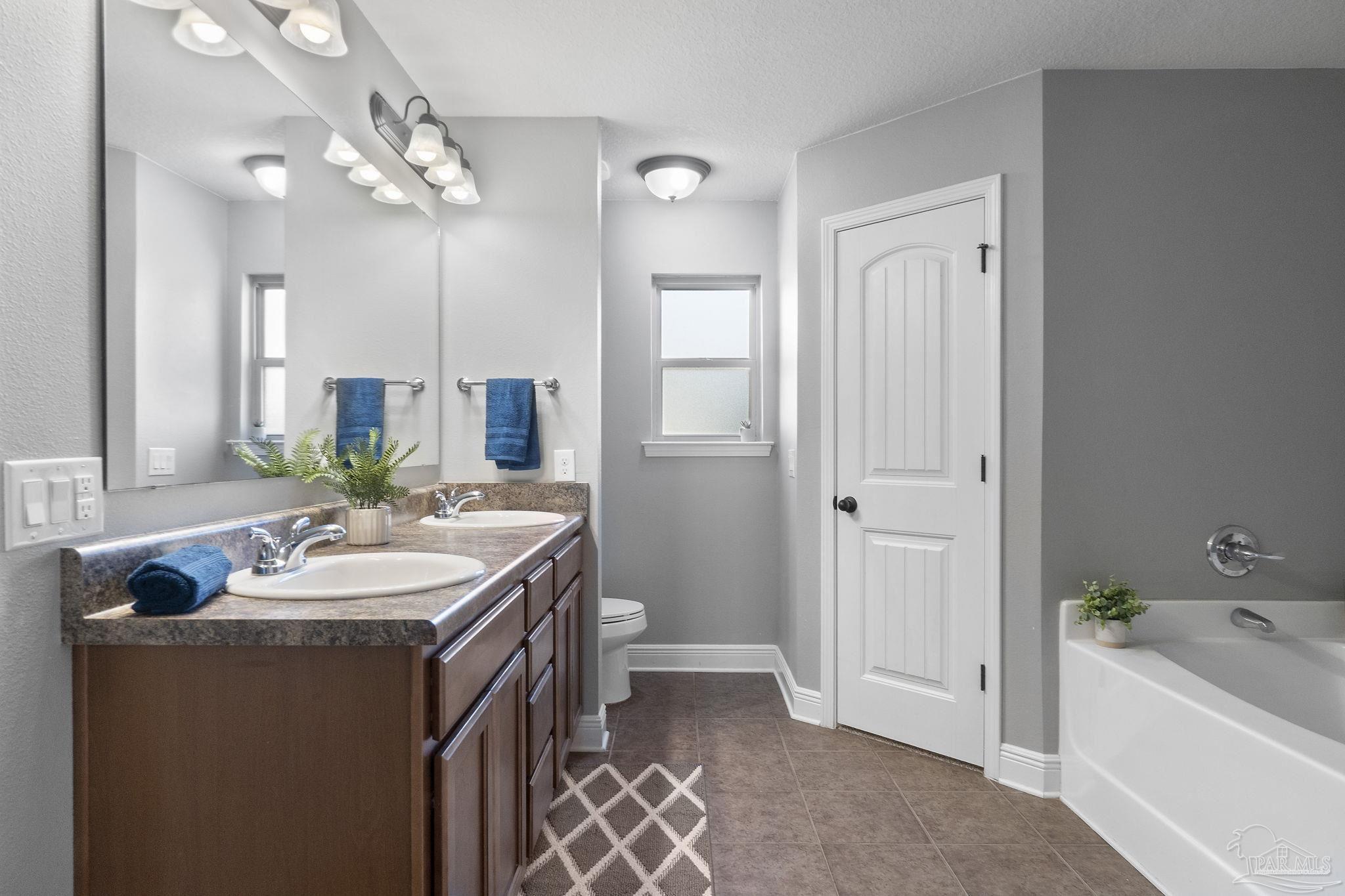 5607 Cane Syrup Circle Pace, FL 32571 - Photo 28 of 54 a bathroom with a tub sink and mirror