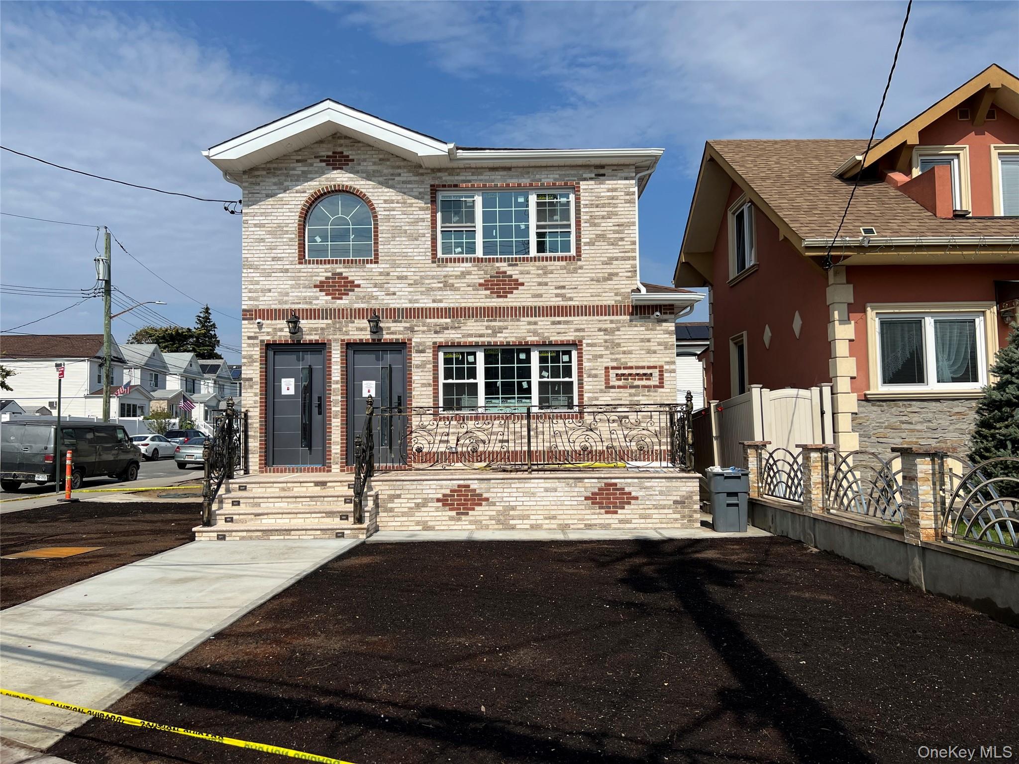 98-29 Albert Road Queens, NY 11417 - Photo 3 of 13 View of front facade with brick siding and a fenced front yard