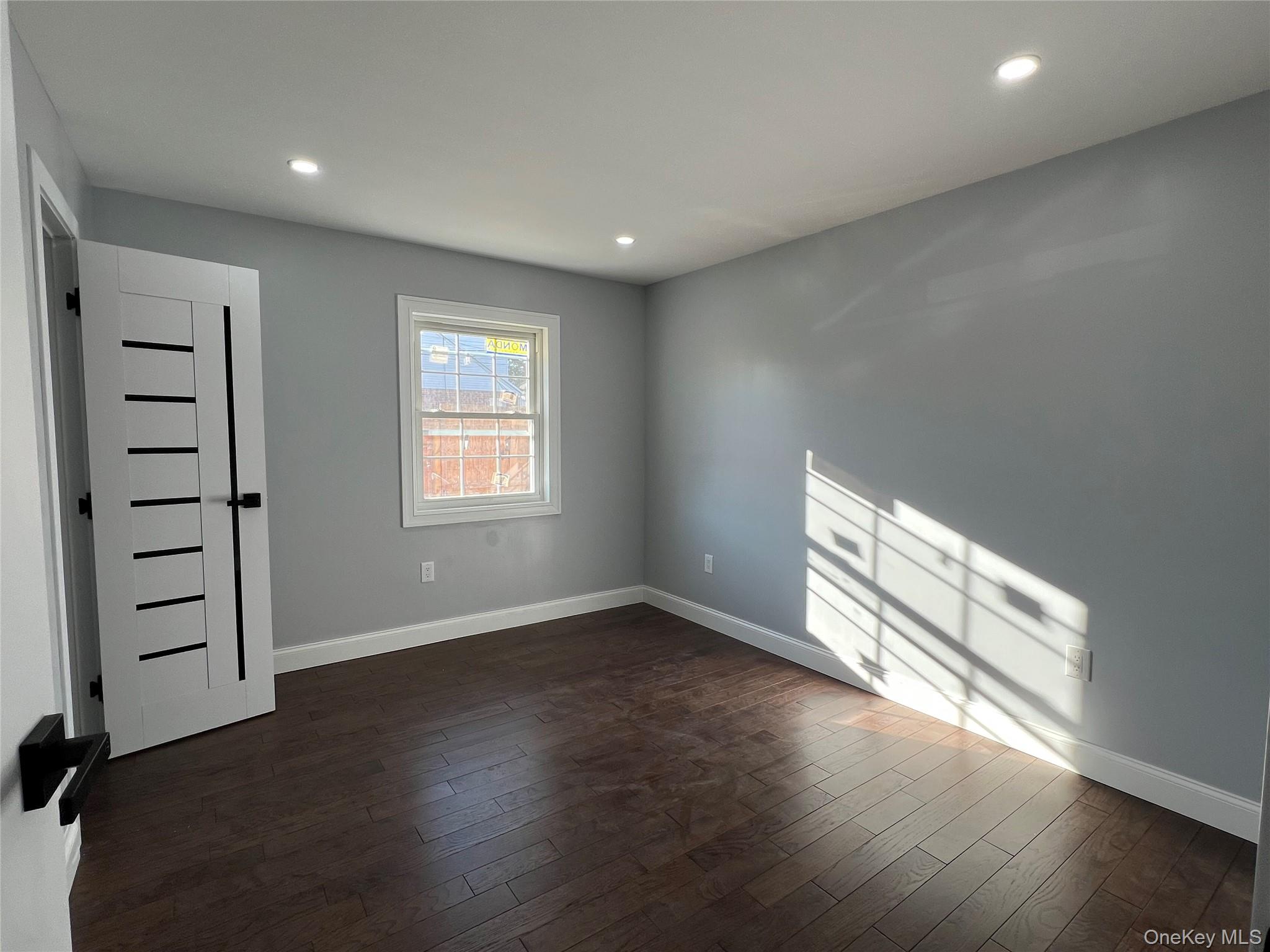 98-29 Albert Road Queens, NY 11417 - Photo 5 of 13 Empty room with recessed lighting and dark wood-style flooring