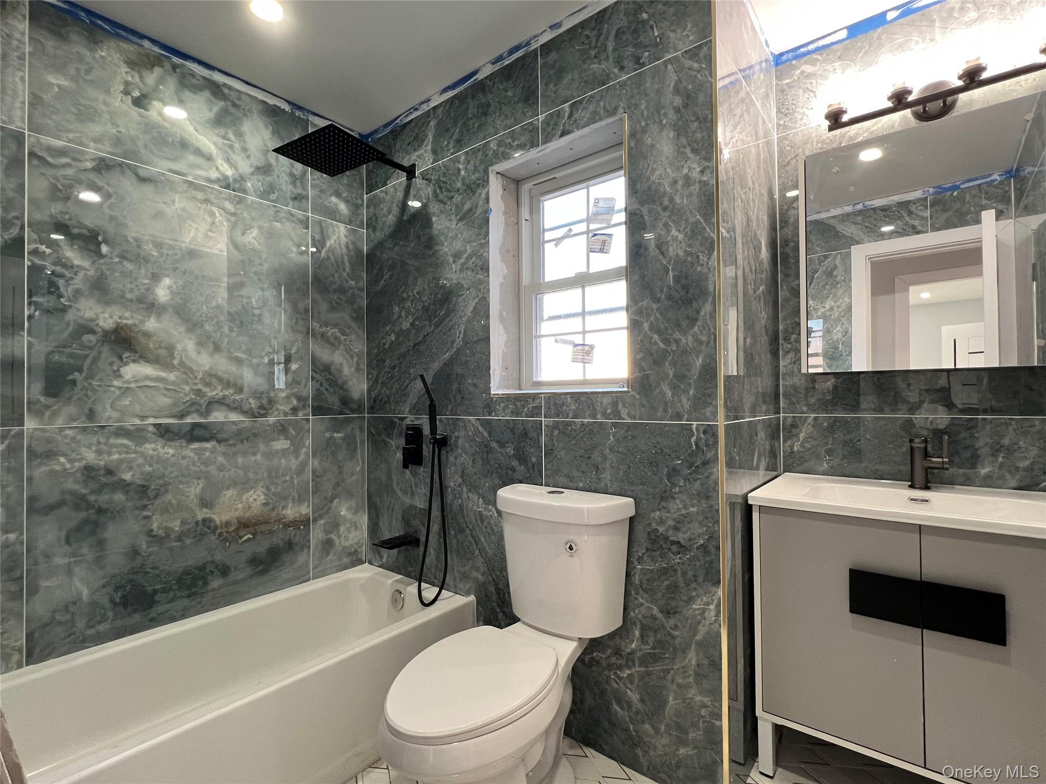 98-29 Albert Road Queens, NY 11417 - Photo 6 of 13 Bathroom featuring tile walls, shower / bath combination, and vanity