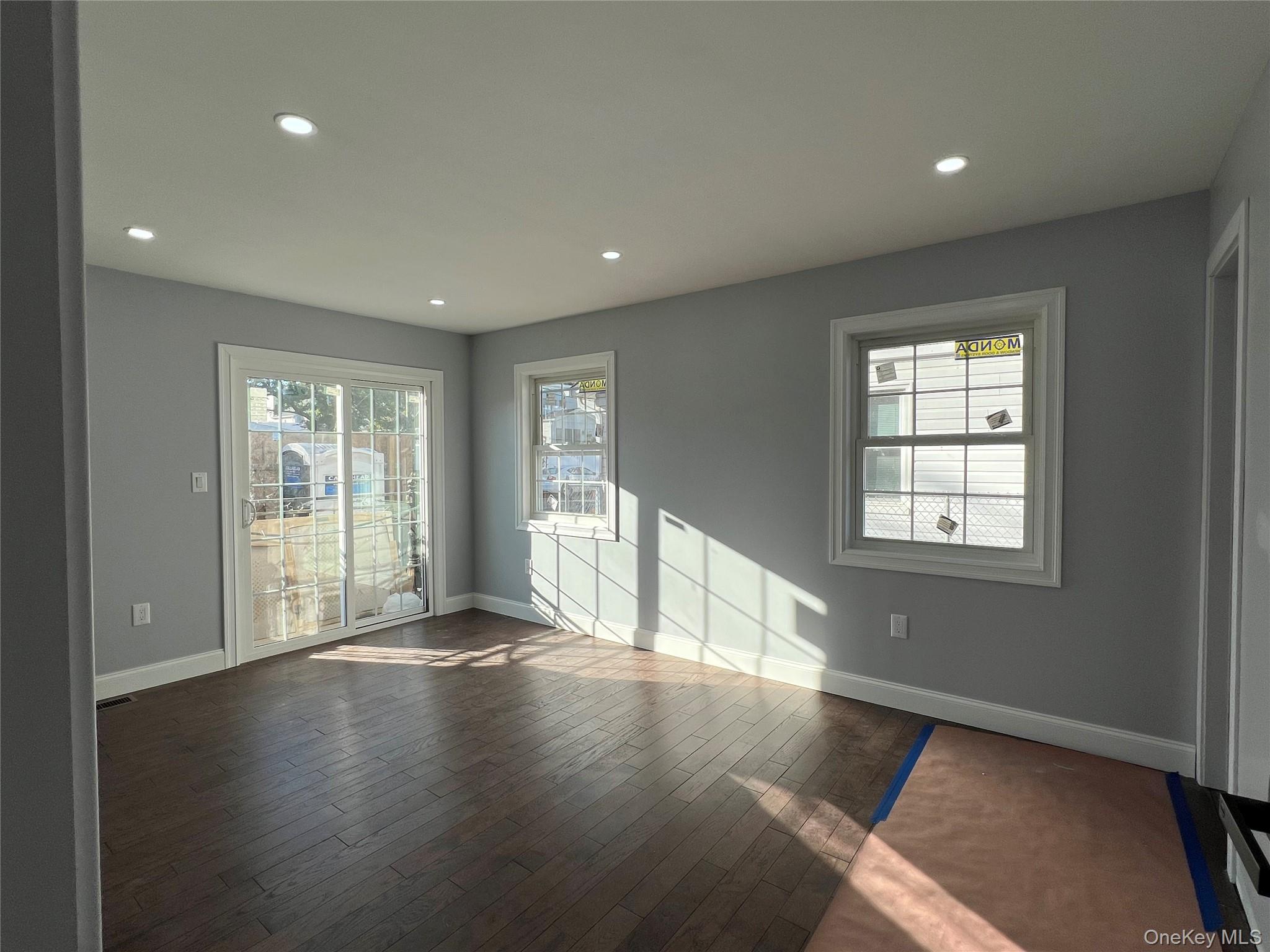 98-29 Albert Road Queens, NY 11417 - Photo 7 of 13 Empty room with recessed lighting, plenty of natural light, and dark wood-style flooring