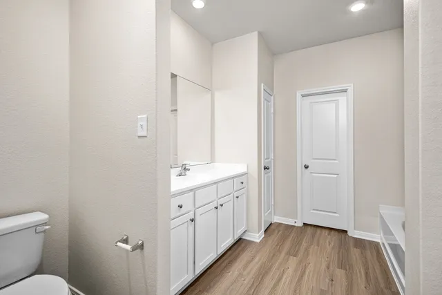 a bathroom with a granite countertop sink toilet and view of bathroom
