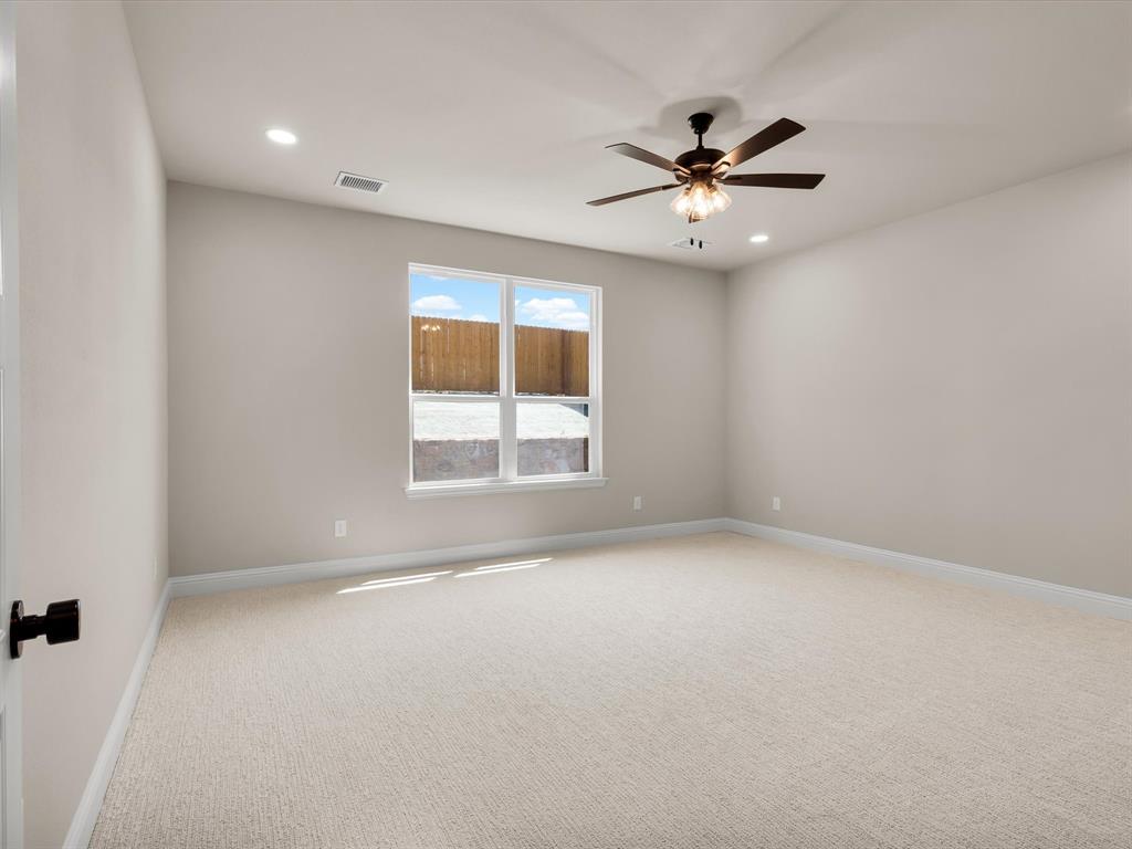 612 Jameson Springtown, TX 76082 - Photo 5 of 13 an empty room with a window and a ceiling fan