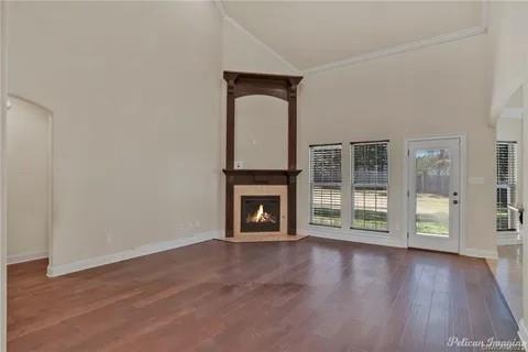 2805 Clearbrook Way Haughton, LA 71037 - Photo 6 of 33 an empty room with wooden floor fireplace and windows
