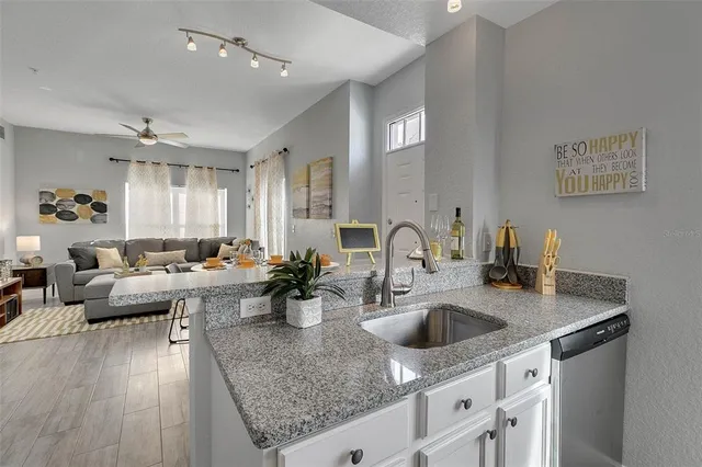 a kitchen with sink cabinets and living room