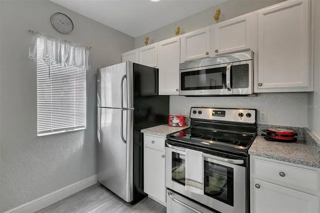 a kitchen with stainless steel appliances a stove a microwave and a refrigerator