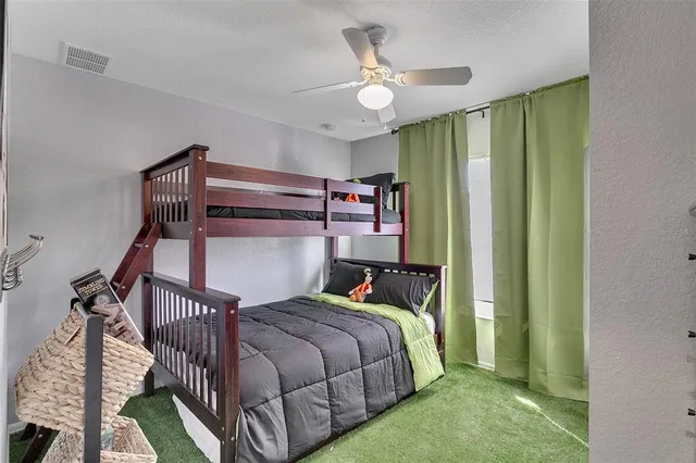 a bedroom with a bed a chandelier and dresser