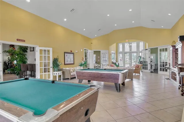 a room with pool table and windows