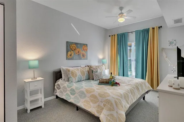 a bedroom with a bed and a flat tv screen on dresser