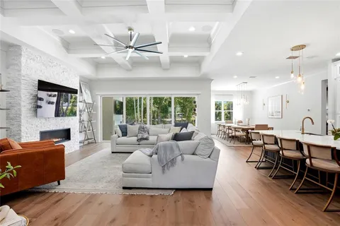 a living room with furniture kitchen view and a large window