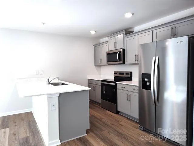 a kitchen with stainless steel appliances a refrigerator stove microwave and sink