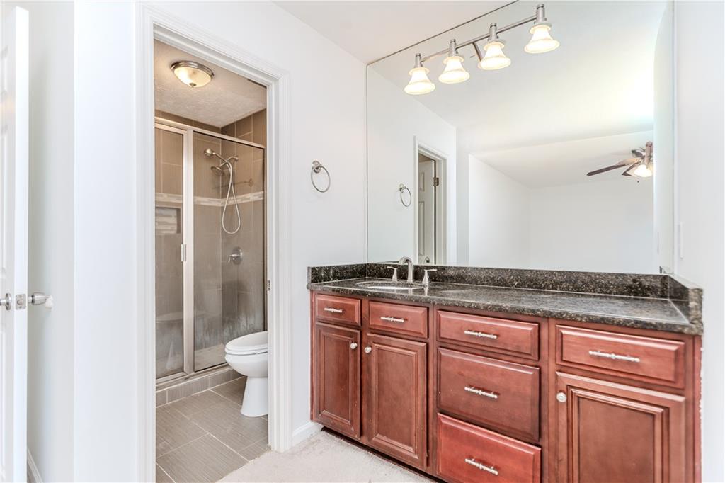 3408 Hamilton Mill Road Buford, GA 30519 - Photo 14 of 32 a spacious bathroom with a granite countertop sink a toilet and a mirror