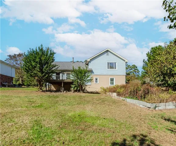 a view of a house with a big yard and large trees