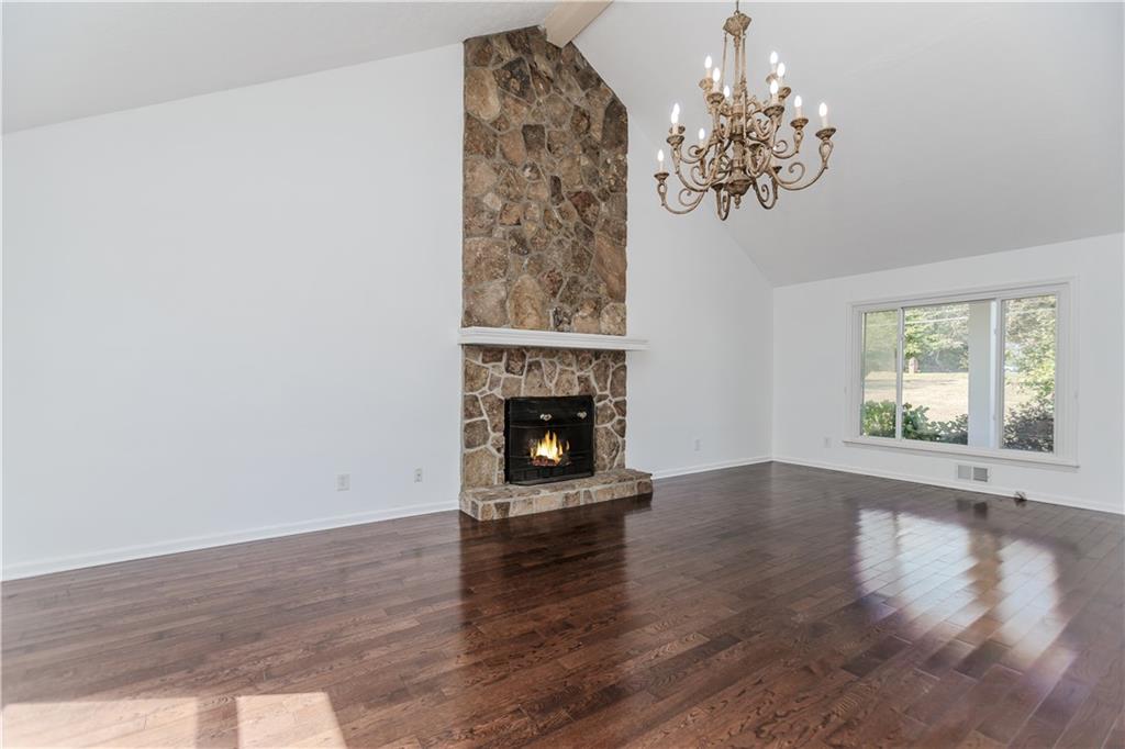 3408 Hamilton Mill Road Buford, GA 30519 - Photo 5 of 32 a view of an empty room with wooden floor and a window