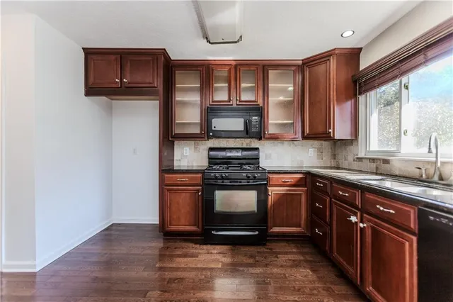 a kitchen with stainless steel appliances granite countertop a stove a sink and a microwave