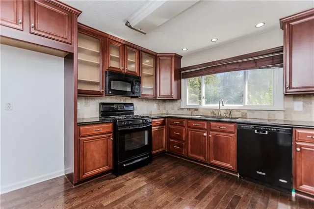 a kitchen with stainless steel appliances granite countertop a stove a sink dishwasher and a microwave oven with granite countertops