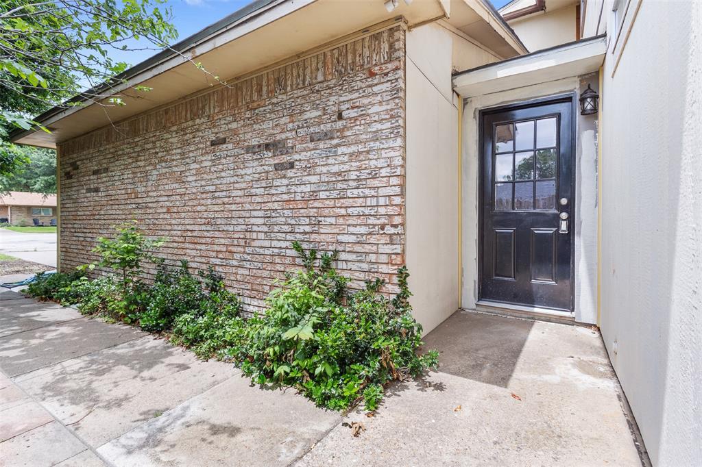 2802 Spring Valley Drive Bedford, TX 76021 - Photo 2 of 24 a pathway of a house with potted plants in front of door