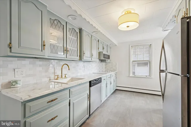 a kitchen with granite countertop a sink stainless steel appliances and cabinets