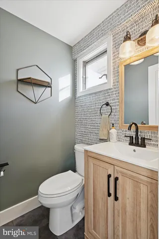a bathroom with a sink a toilet and mirror