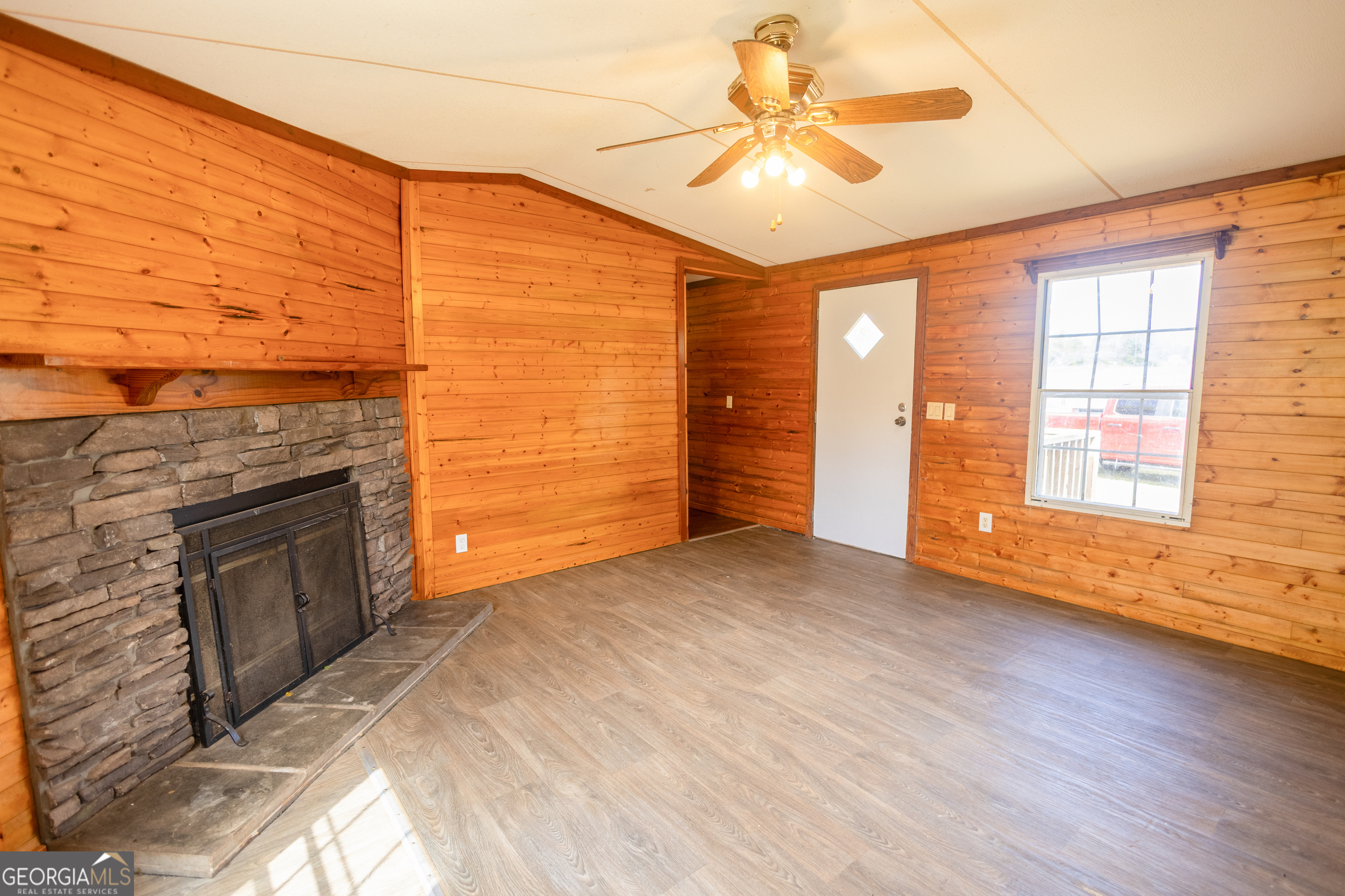 35 Brooks Street Canon, GA 30520 - Photo 4 of 25 an empty room with windows fireplace and wooden floor