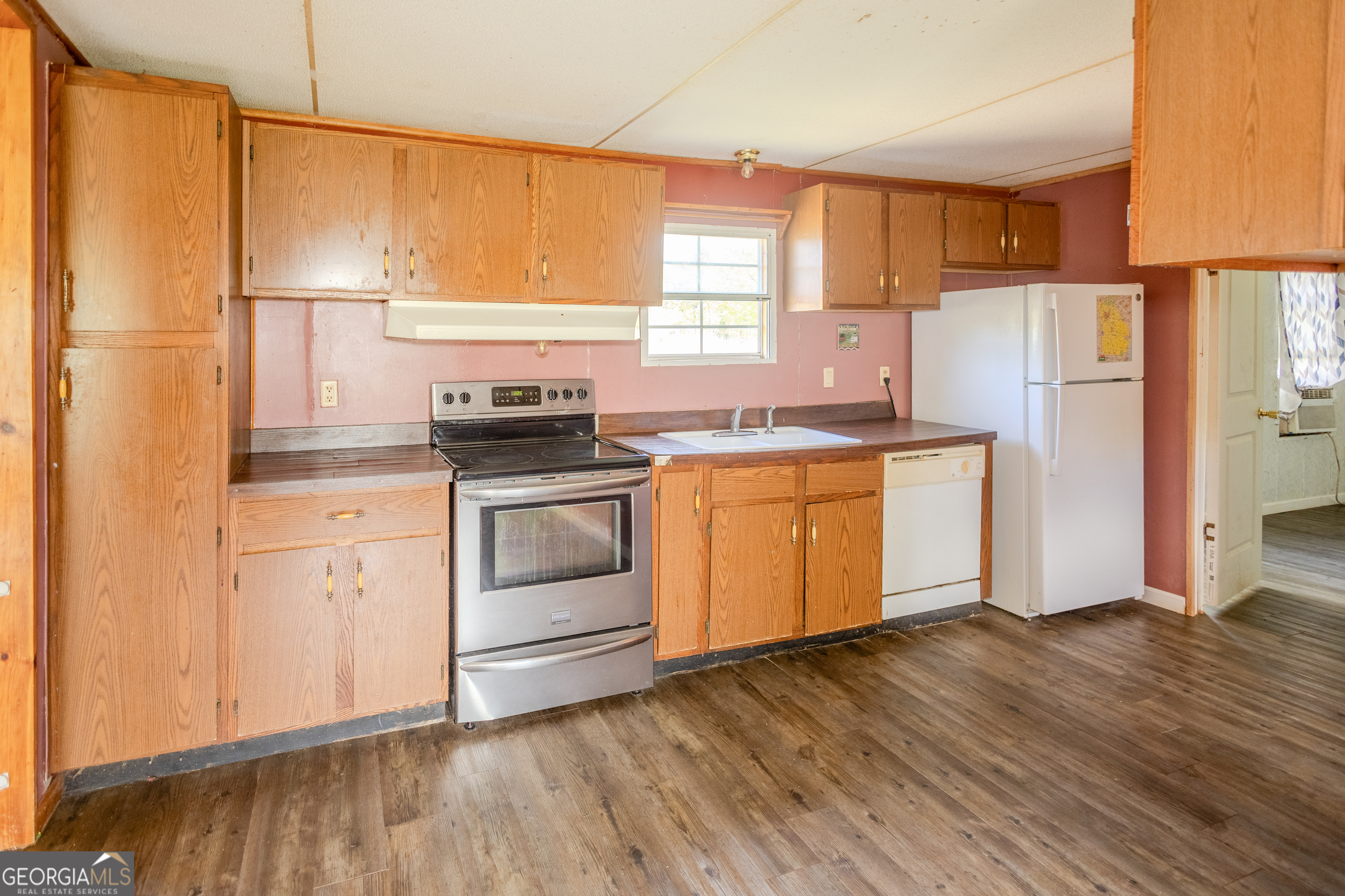 35 Brooks Street Canon, GA 30520 - Photo 6 of 25 a kitchen with a stove a sink white cabinetry and wooden floor