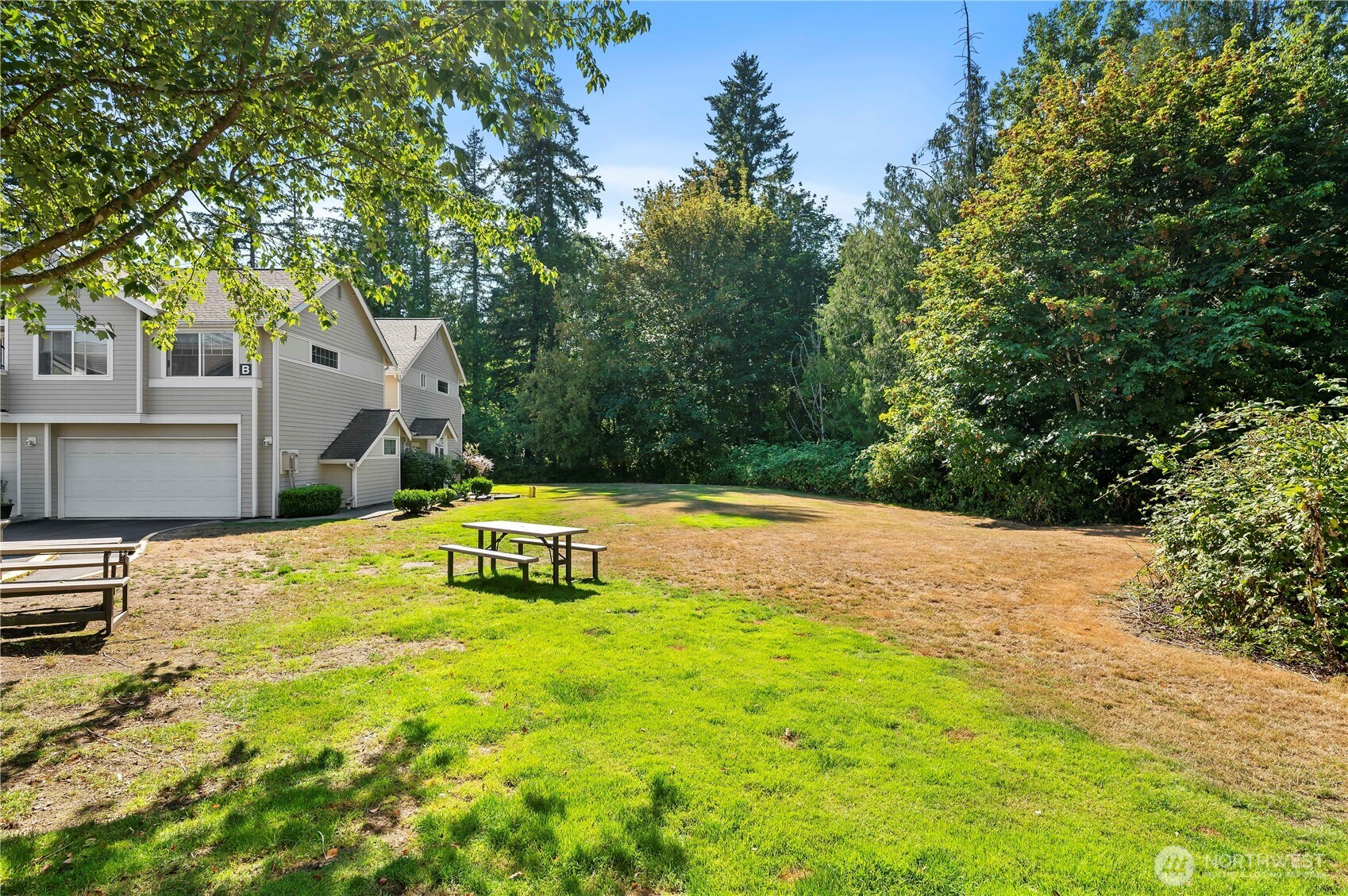 1522 196th Street Southeast, Unit C103 Bothell, WA 98012 - Photo 17 of 24 a yellow house with trees in front of it