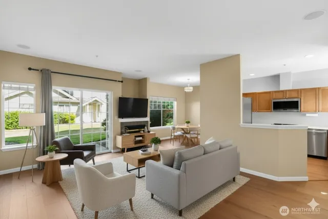a living room with furniture flat screen tv and a large window