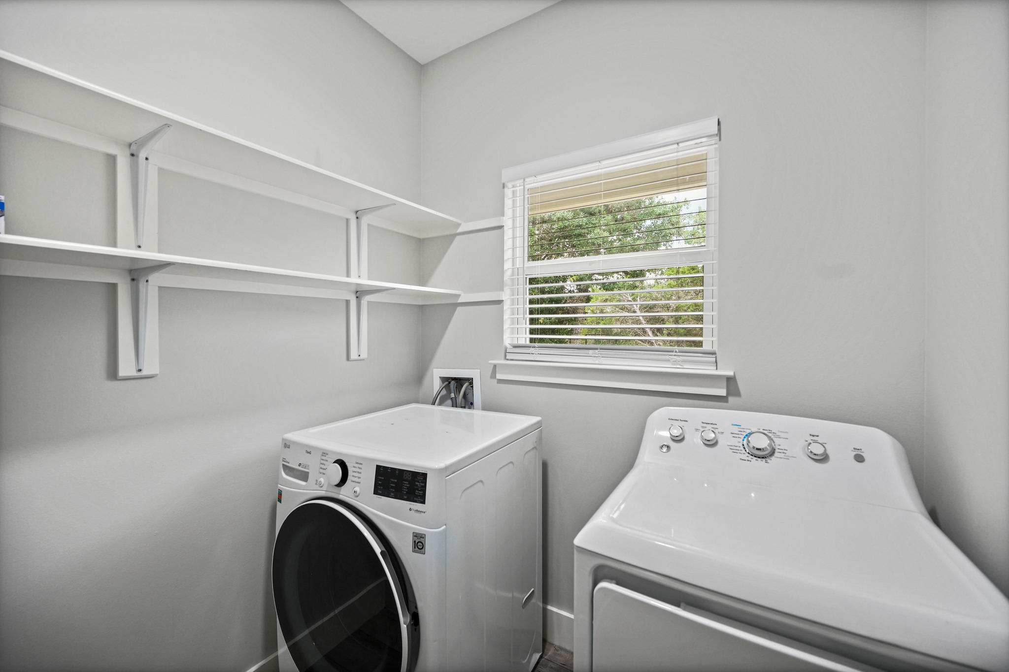 231 North Rainbow Ranch Road Wimberley, TX 78676 - Photo 24 of 40 Ample shelving for organized storage complements modern laundry appliances in this efficient utility space.