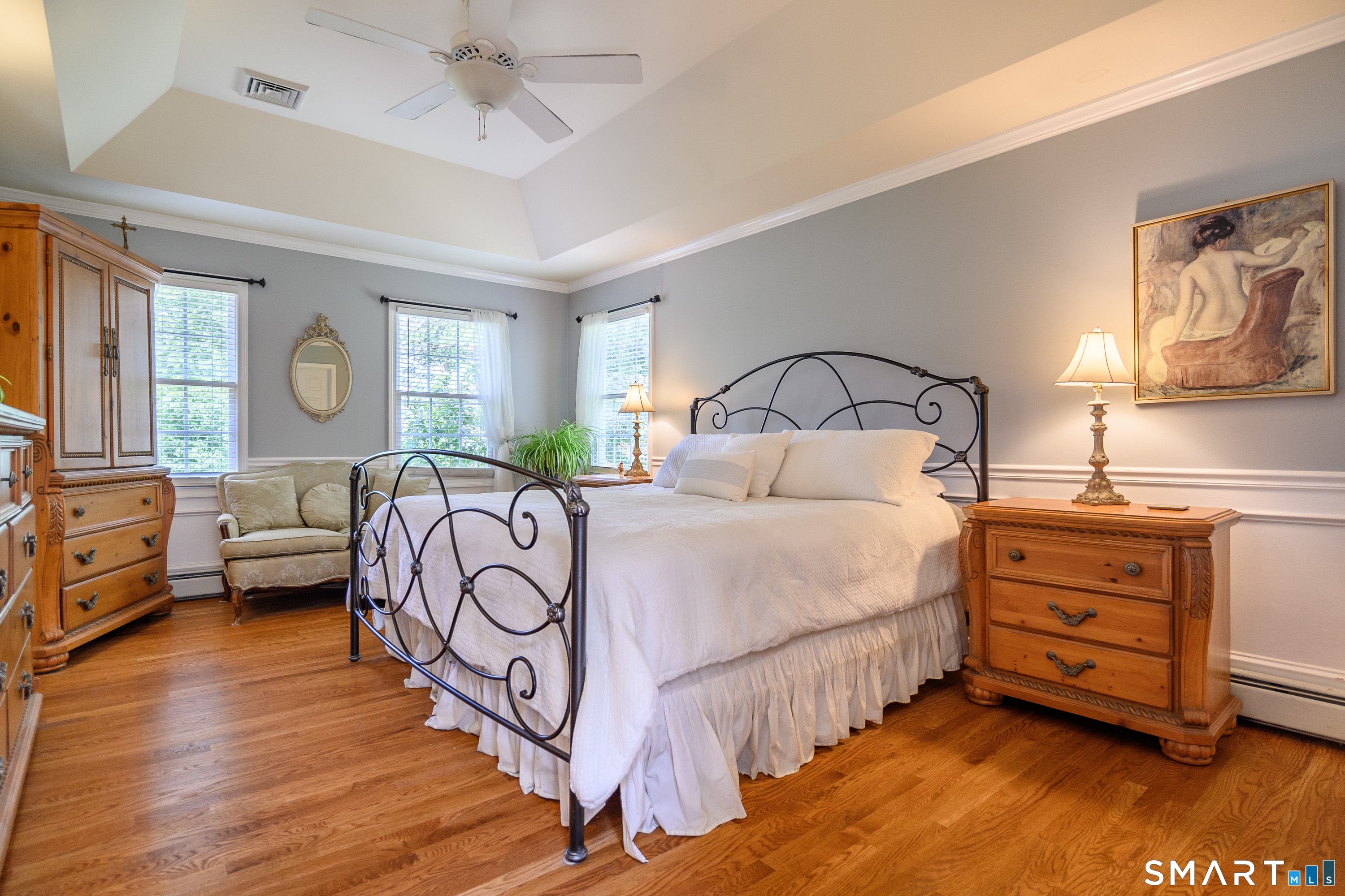 21 Phyllis Lane Newtown, CT 06470 - Photo 19 of 40 Primary bedroom featuring tray ceiling, hardwood floors, and elegant moldings.