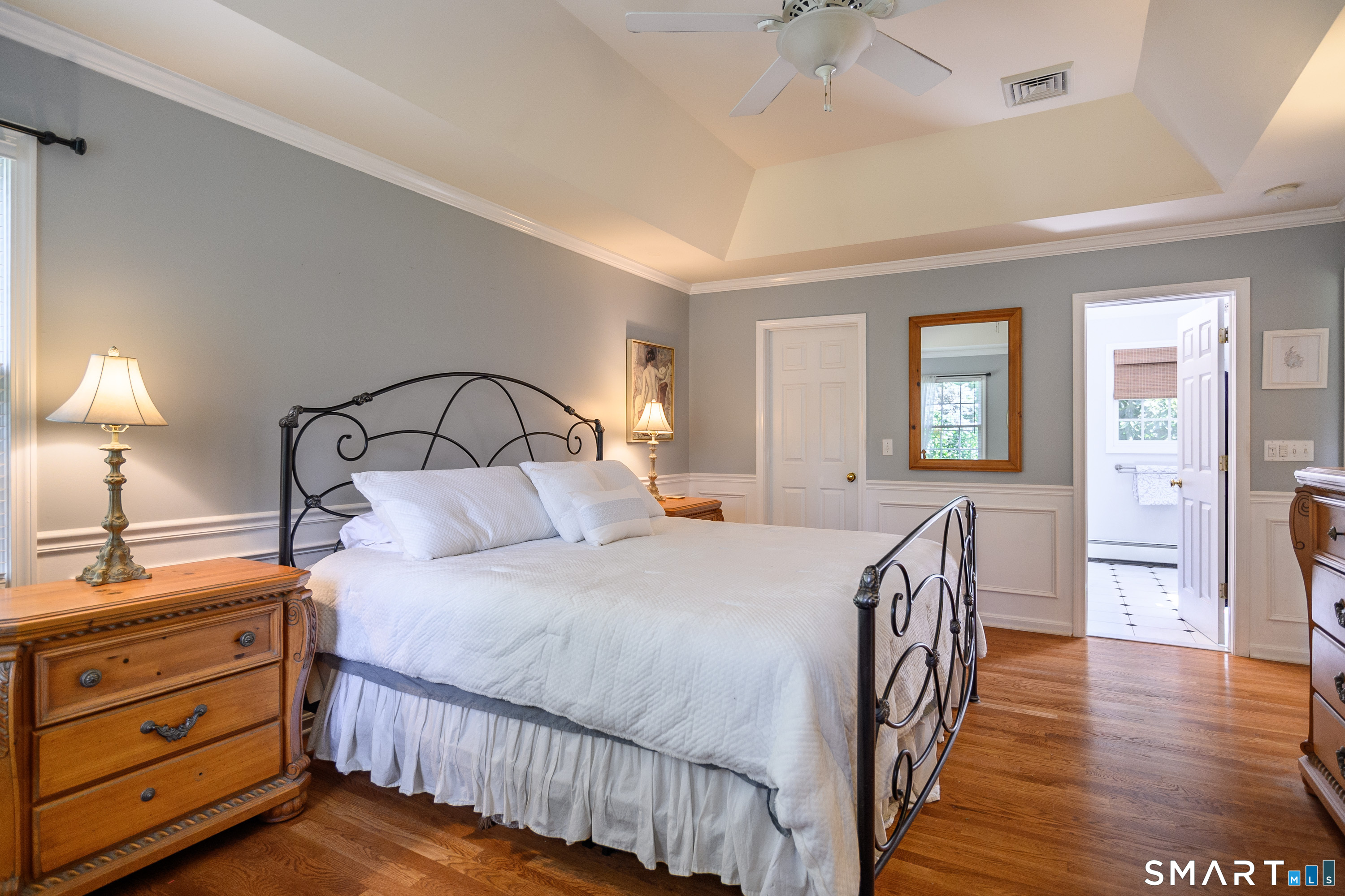 21 Phyllis Lane Newtown, CT 06470 - Photo 20 of 40 Primary bedroom featuring tray ceiling, hardwood floors, and elegant moldings.