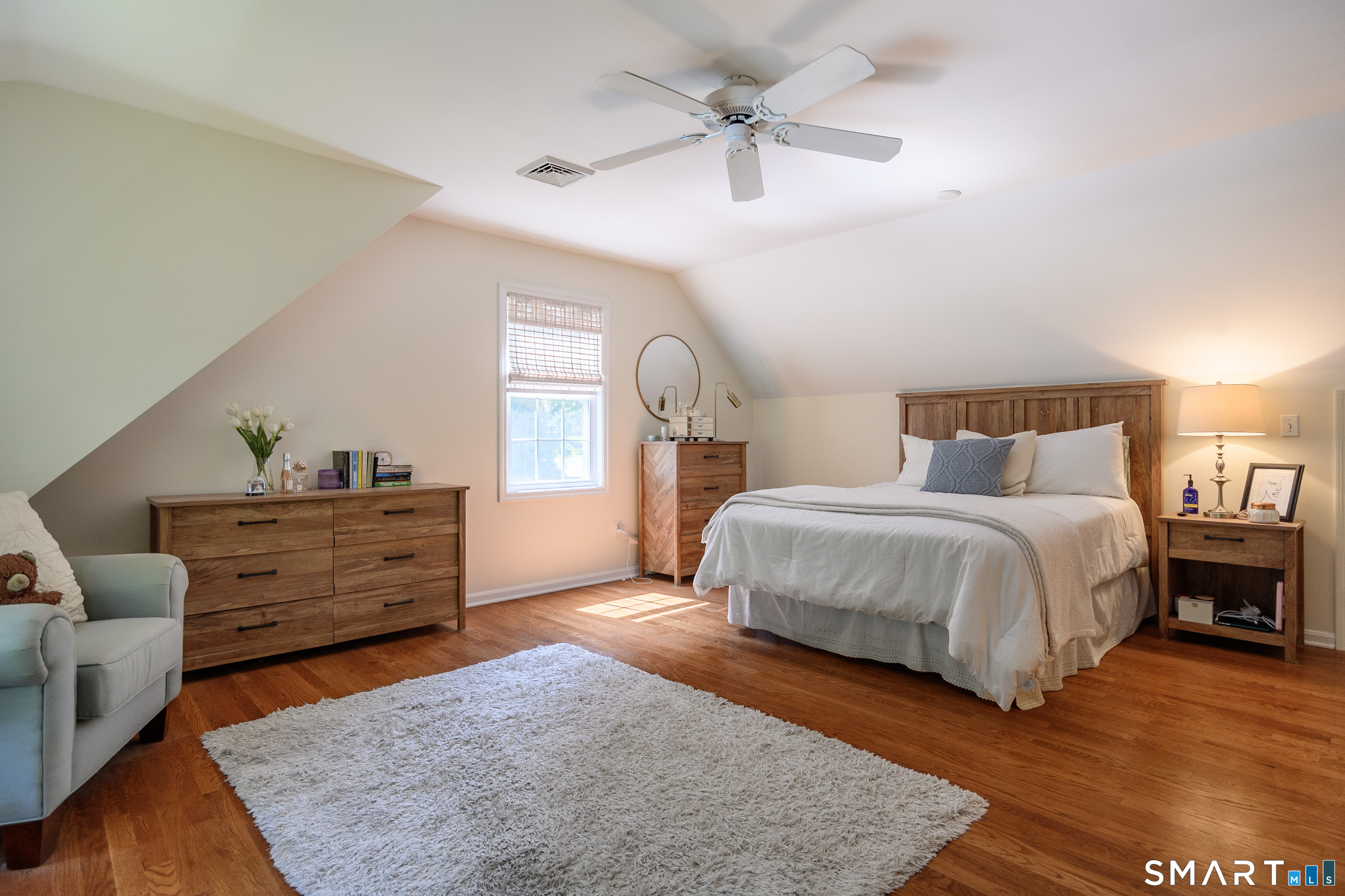 21 Phyllis Lane Newtown, CT 06470 - Photo 25 of 40 Bright bedroom with hardwood floors, ceiling fan, and cozy sitting area.