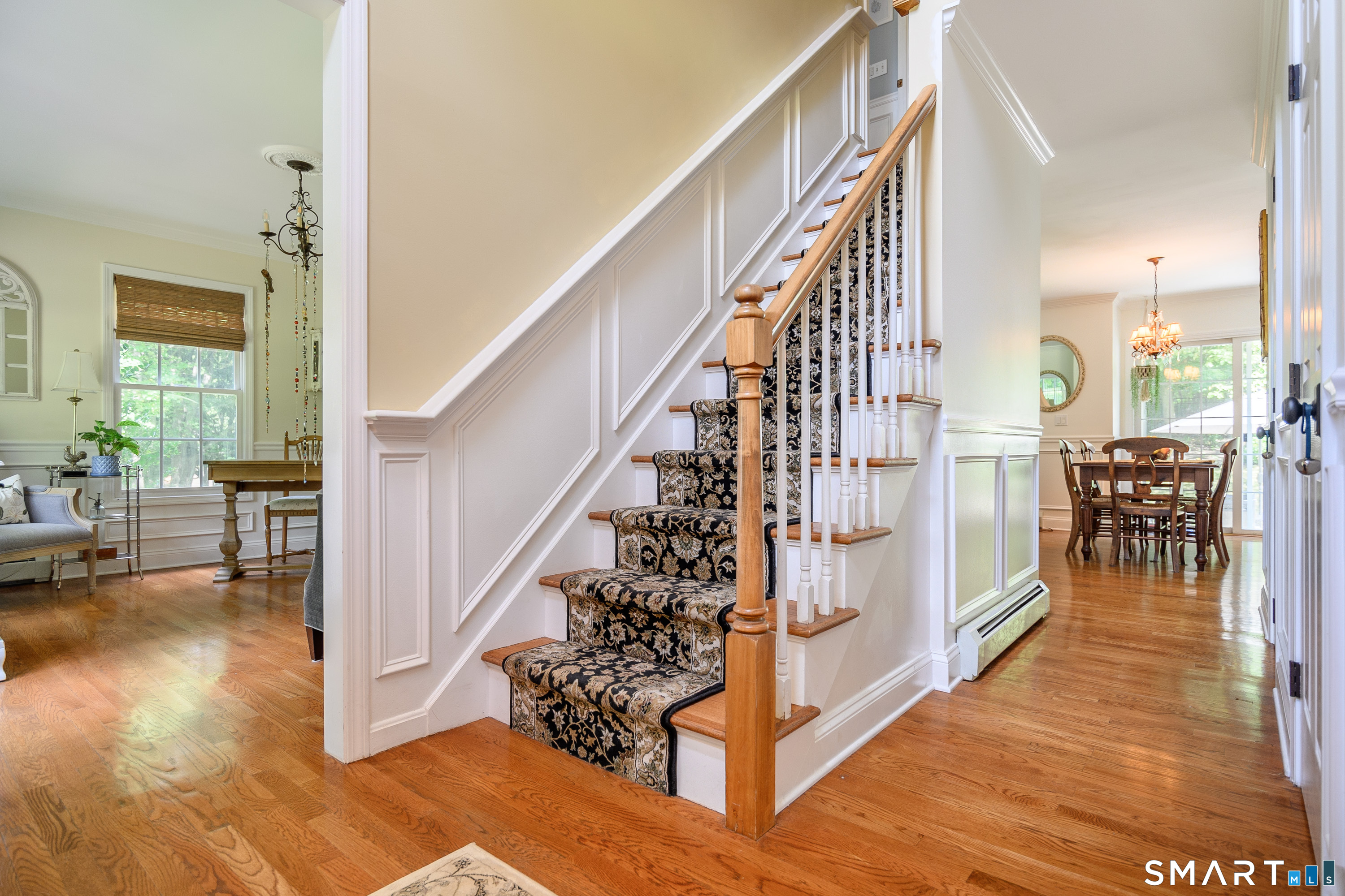 21 Phyllis Lane Newtown, CT 06470 - Photo 3 of 40 Bright foyer with hardwood floors, detailed wainscoting, and staircase with decorative runner.