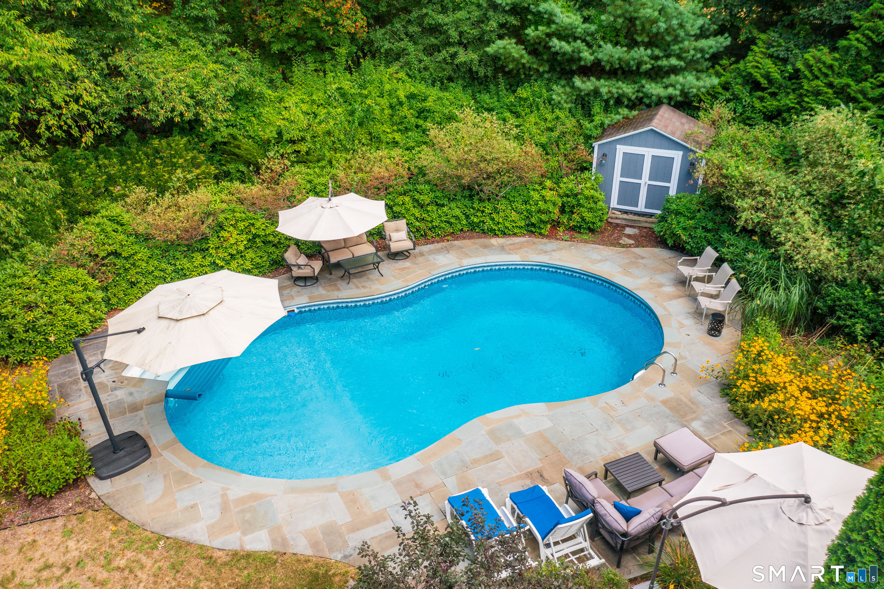 21 Phyllis Lane Newtown, CT 06470 - Photo 32 of 40 Inviting in-ground pool surrounded by stone patio and mature landscaping.