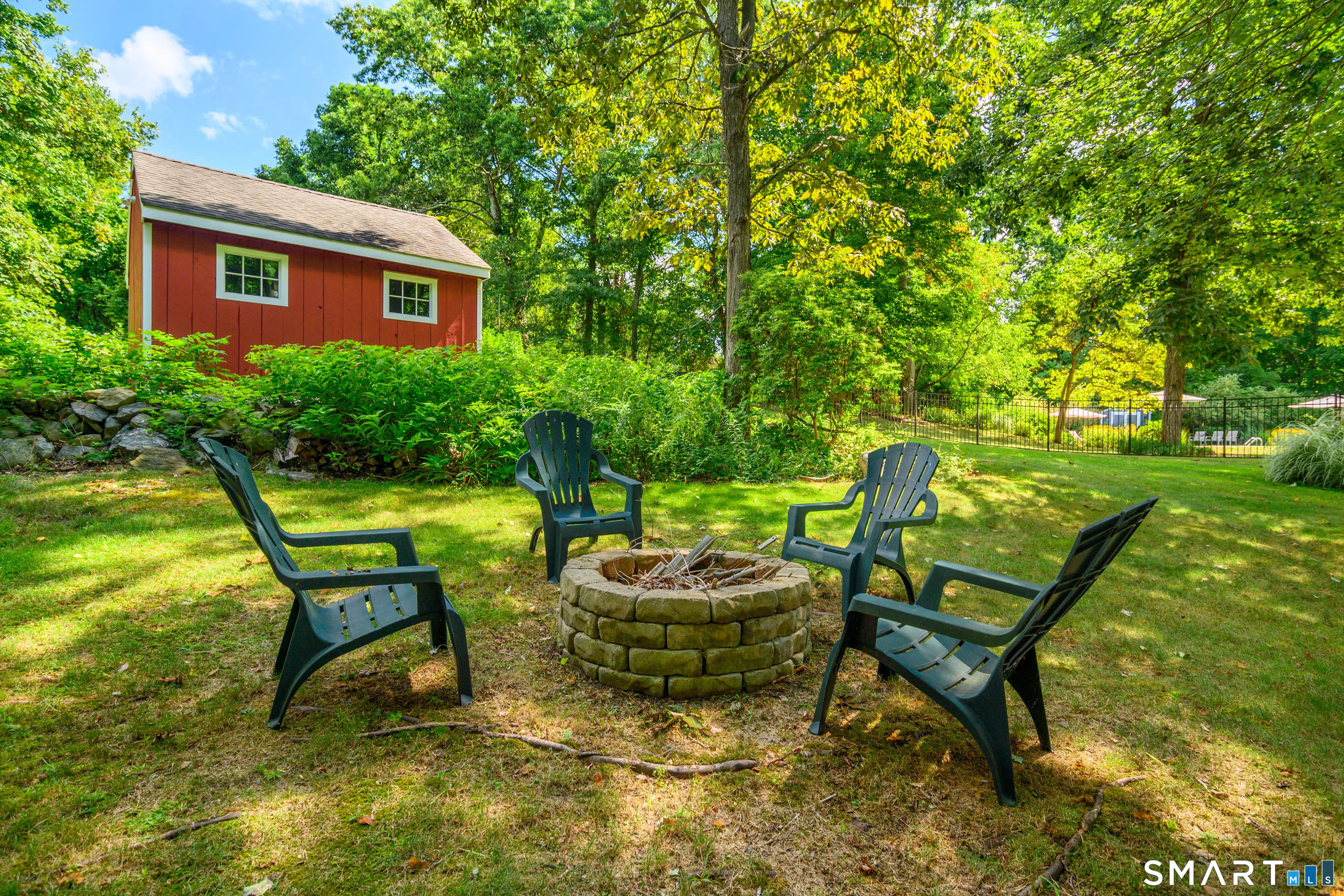 21 Phyllis Lane Newtown, CT 06470 - Photo 37 of 40 Private backyard fire pit area with stone surround and seating. Perfect for relaxing evenings.
