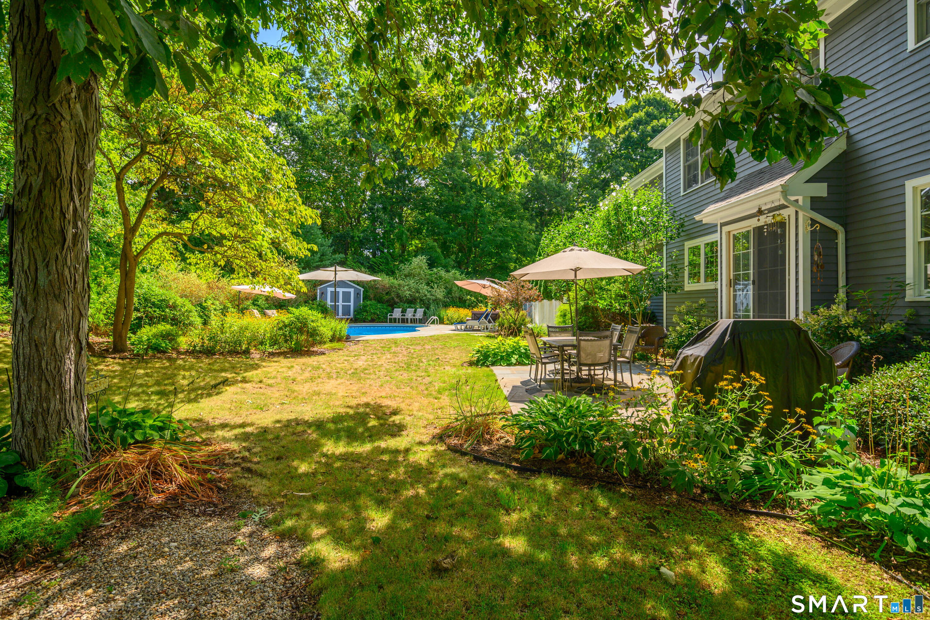 21 Phyllis Lane Newtown, CT 06470 - Photo 40 of 40 Beautifully landscaped backyard with mature plantings and views of the home and pool area.