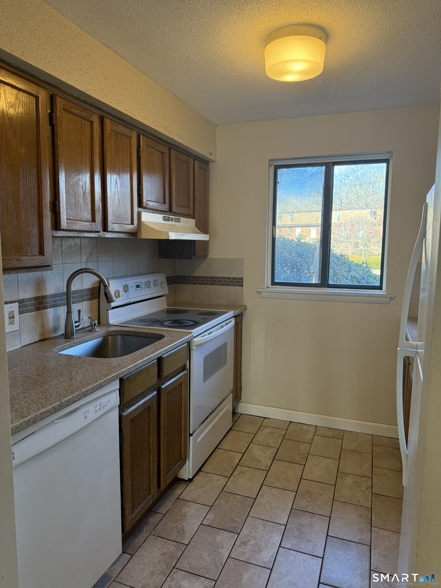 11 King Arthur Drive, Unit 2H East Lyme, CT 06357 - Photo 7 of 10 a kitchen with a sink a stove cabinets and a window
