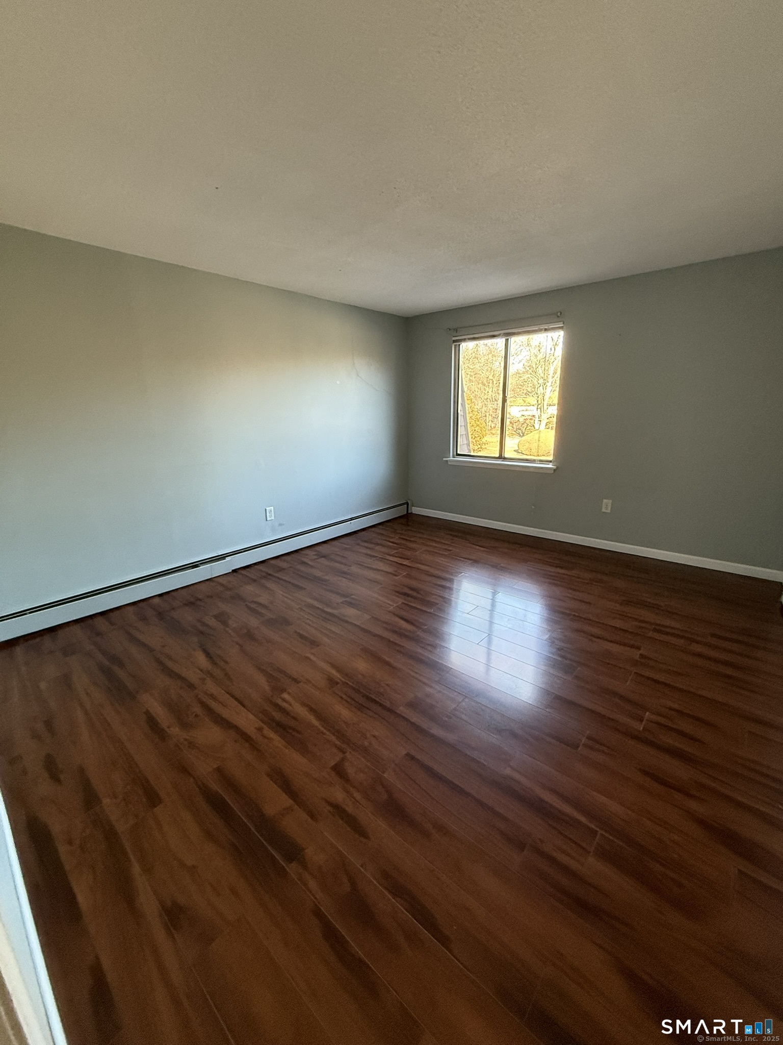 11 King Arthur Drive, Unit 2H East Lyme, CT 06357 - Photo 8 of 10 a view of empty room with wooden floor and fan