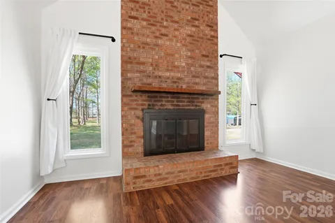a living room with a fireplace and wooden floor