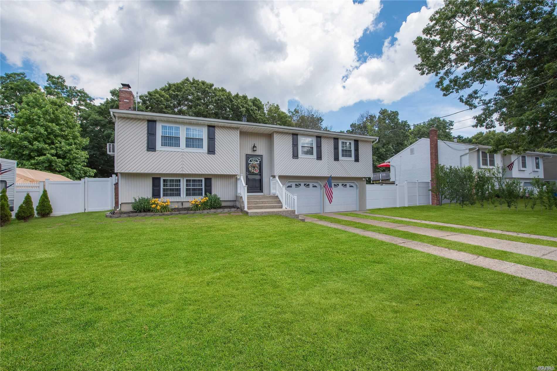 a view of a house with a big yard and large tree